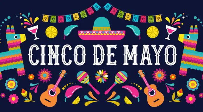 Dark purple banner with colorful pinatas, guitars, and sombreros all over and words, 'Cinco de Mayo', in white on the center.
