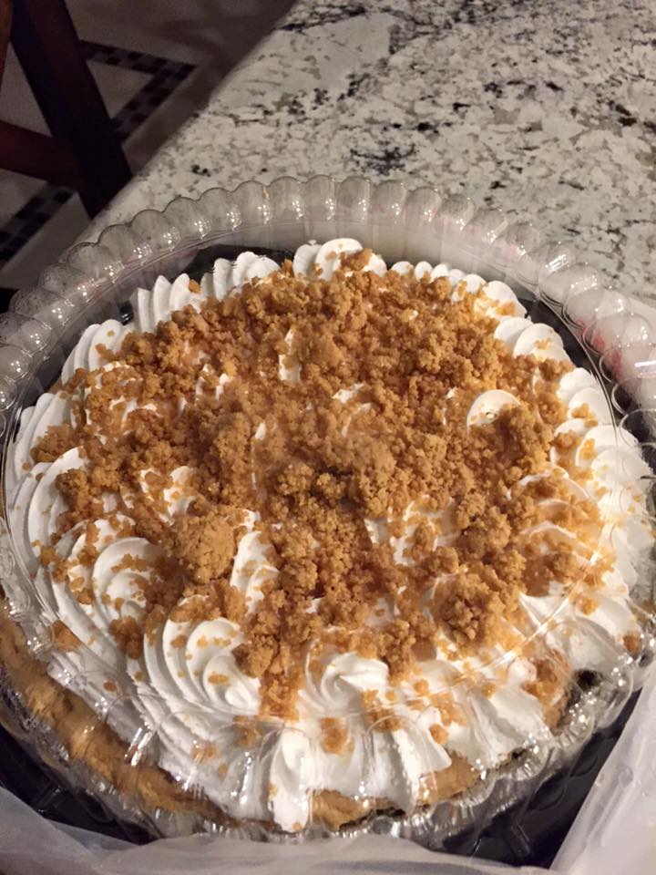 Large coconut cream pie on top of a Las Tiendas wooden table.