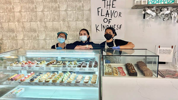Three women in front a bakery counter with pastries stacked inside a 17th street McAllen restaurant.