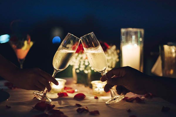 Two people clinking glasses of champagne at several bars in McAllen.