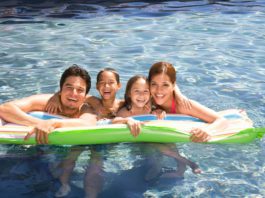 A Hispanic family swimming in a pool and enjoying McAllen living.