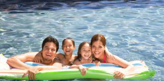 A Hispanic family swimming in a pool and enjoying McAllen living.