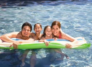 A Hispanic family swimming in a pool and enjoying McAllen living.