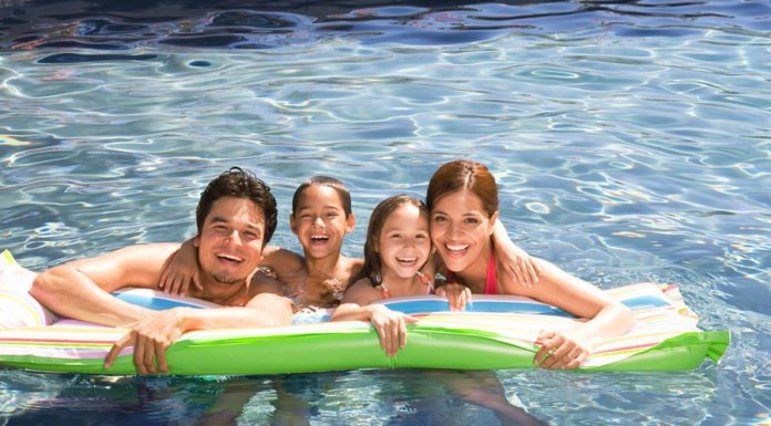 A Hispanic family swimming in a pool and enjoying McAllen living.