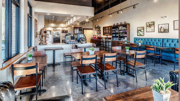 A unique New-Orleans born coffee shop opening in McAllen with wooden rustic chairs and a brightly lit interior.