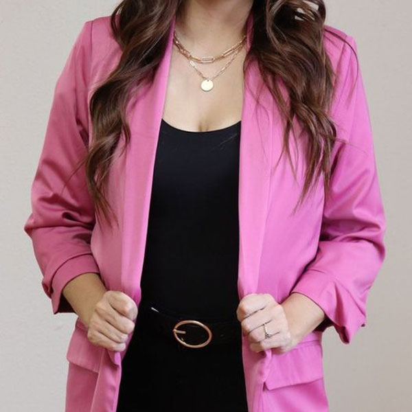 woman in pink blazer posing in front of McAllen stores